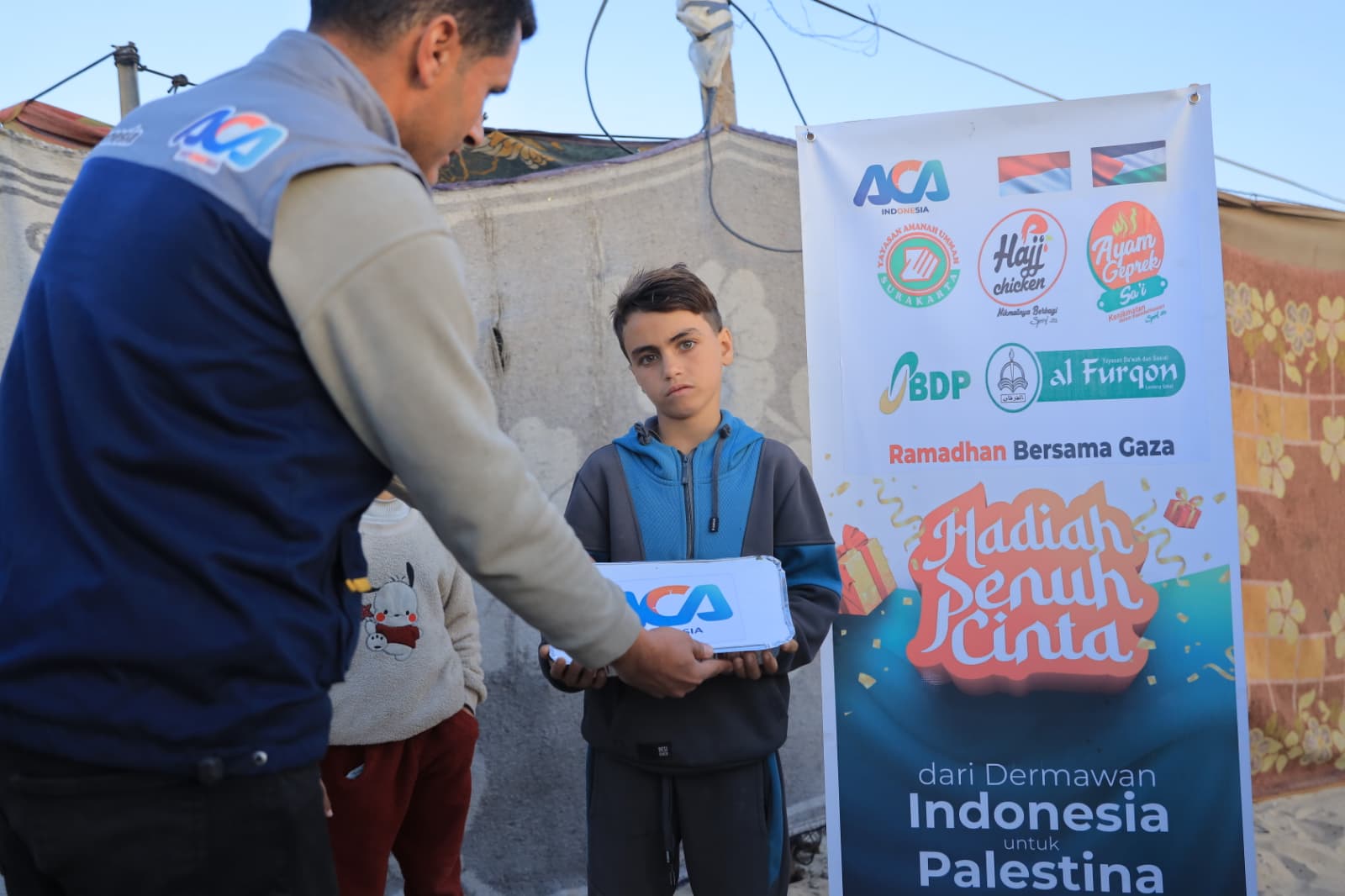 Relawan ACA Indonesia menyerahkan paket iftar kepada seorang anak di Gaza
