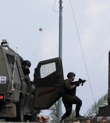 Tentara Israel membidik senjata dari samping kendaraan lapis baja di tepi jalan