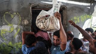 Warga Palestina berdesakan mengantre roti di depan sebuah toko roti di Gaza di tengah kelangkaan tepung